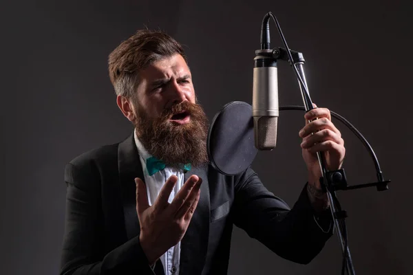 Un hombre guapo en el estudio de grabación. Interpretación musical vocal. Festival de música. Cantante cantando canción con un micrófono. — Foto de Stock