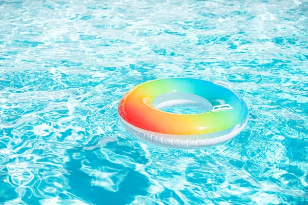 Flotador de la piscina, anillo flotando en una refrescante piscina azul sobre fondo de verano. — Foto de Stock