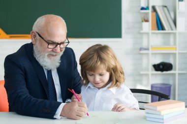 Okuldaki mutlu çocuk. Öğretmenin öğrenmesine yardım et. Eğitim, öğretmenlik, ilkokul.