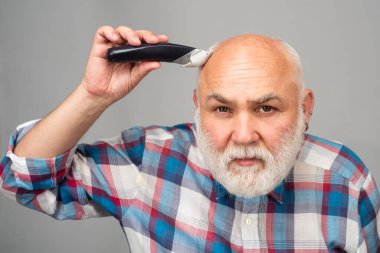 Kel adam saç kesicisi, olgun kellik ve saç dökülmesi konsepti. Orta yaşlı gri adam.