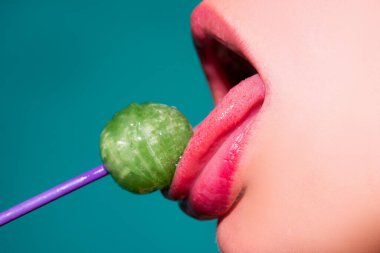 Dilini yalıyor. Seksi ağzı olan, chupa yiyen bir kız. Kadın dudakları lolipop emiyor. Ağzında lolipop tutan kadın, kapat. Kırmızı dudaklar, şehvetli ve seks dükkanı konsepti.