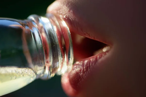 Kvinnors mun dricker vatten från flaskan. Närbild dricka vatten. Sensuella läppar. — Stockfoto