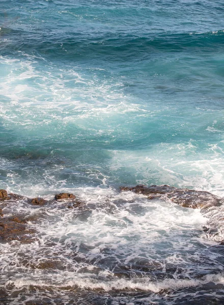 Przybrzeżny krajobraz z błękitnym morzem i pięknymi klifami. Kamienne skały na wybrzeżu w błękitnej wodzie. — Zdjęcie stockowe
