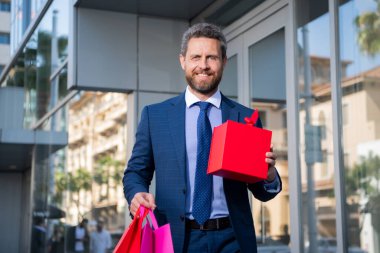 Alışveriş çantalı bir iş adamı. Yakışıklı, kendine güvenen bir iş adamı portresi..