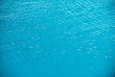 Yüzme havuzunda yırtık su. Mavi yüzme havuzunun yüzeyi, suyun arka planı.