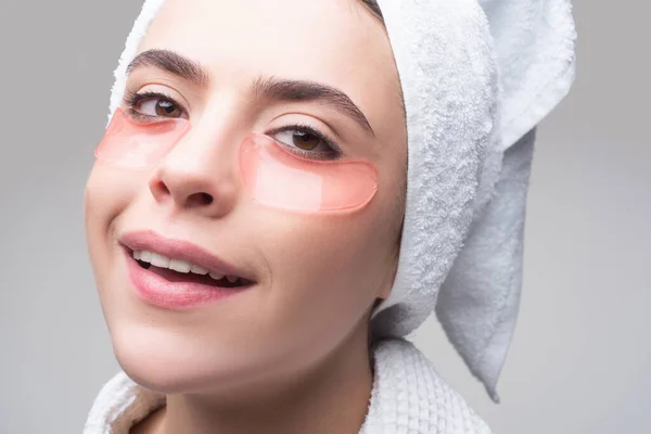 Muchacha de retratos con toalla en la cabeza. Retrato de mujer de belleza con parches en los ojos que muestran un efecto de la piel perfecta. Chica morena spa. Ojos máscara parches cosméticos cara de mujer primer plano. —  Fotos de Stock