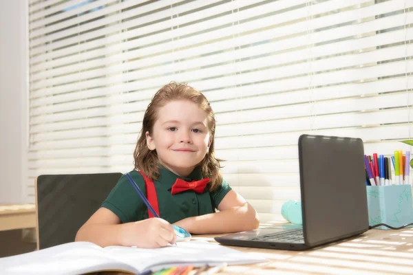 Smart allievo sorridente scuola bambino virtuale apprendimento a distanza online, guardando lezione di classe digitale remota, guardando computer portatile studiare a casa, scrivere note. — Foto Stock