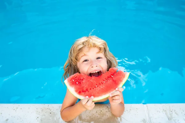 Barn med vattenmelon i poolen utomhus. Grabben har kul i poolen. Barn sommarsemester och hälsosam kost koncept. — Stockfoto