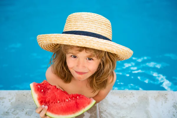 Niño feliz con rebanada de sandía dulce fresca sonriendo, mientras nada en la piscina en el día de verano. — Foto de Stock