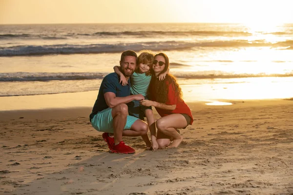 Joyeux câlin familial embrassant sur la plage. Père et enfants jouent sur la plage. Concept de famille amicale. — Photo