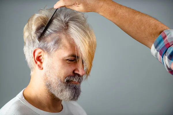 Friseur schneidet männliche Haare, Nahaufnahme. Friseur macht Haare mit schwarzem Kamm von gutaussehenden Kunden in professionellen Friseursalon. Friseurkonzept. — Stockfoto