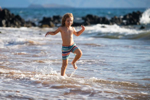 Bambino attivo che schizza tra le onde del mare in una giornata estiva durante le vacanze. Il concetto di vacanze in famiglia con bambini. — Foto Stock