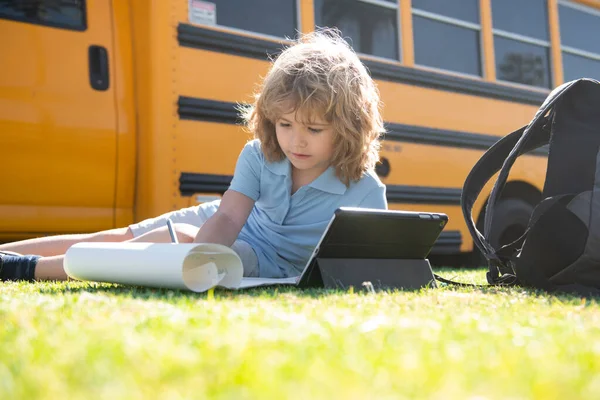 Kinderstudie online mit Tablet im Park. Soziale Distanz während der Quarantäne, Online-Bildungskonzept, Hausaufgabenbetreuung außerhalb. — Stockfoto