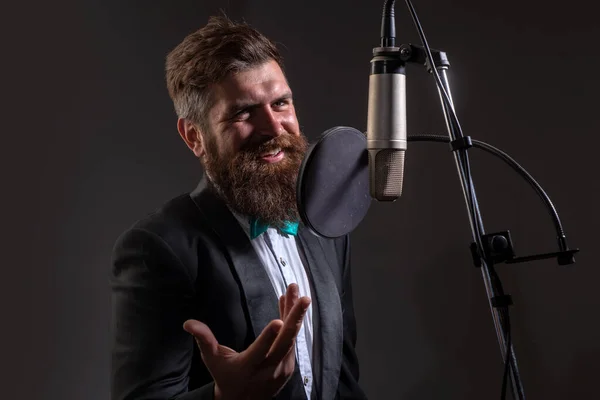Classical music. Singing man in a recording studio. Expressive bearded man with microphone. Karaoke signer, musical vocalist.