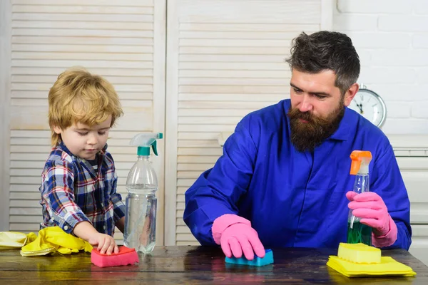 Man städar tillsammans hemma. Far och son med rena förnödenheter. Föräldrar och barn med gummihandske i skumplast. Begreppet städning av familjeaktiviteter. — Stockfoto