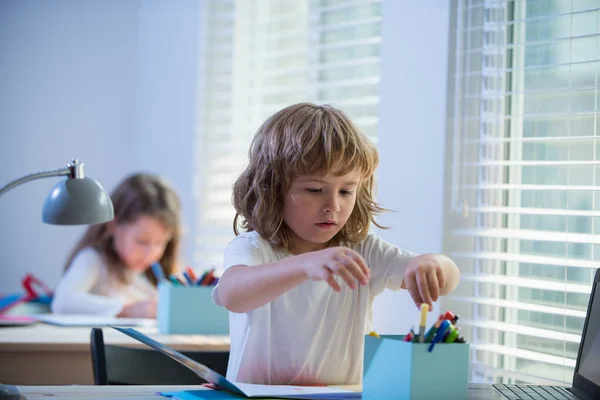 Školák dělá domácí úkoly. Žák se připravuje do školy. Portrét dítěte ve škole na třídním pracovišti. — Stock fotografie