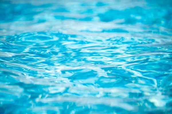 Bakgrund av blått vatten i poolen med sol reflektion, krusning vatten våg i poolen. Klar vatten bakgrund. — Stockfoto