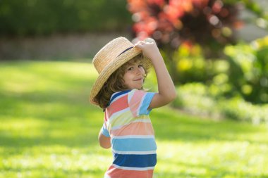 Yaz parkındaki sevimli bir çocuğun portresi. Hasır şapkalı beyaz çocuğu kapatın. Komik çocuk. Yaz tatili.