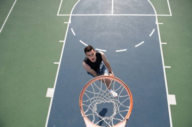 Basketbol sahasında oynayan genç bir sporcu..