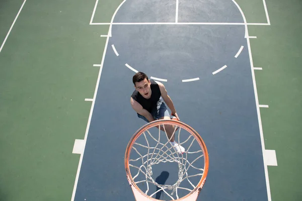 Junger Sportler spielt Basketball auf Basketballplatz im Freien. — Stockfoto