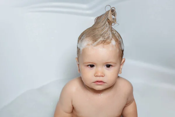 Vicces gyerek, aki habban fürdött és otthon fürdött a kádban. Todler zuhany alatt, vicces csecsemő zuhany alatt. — Stock Fotó