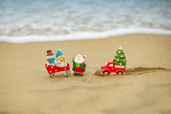 Mikołaj i bałwan dekoracji na plaży oceanu. Święta Bożego Narodzenia i Nowy Rok wakacje w gorących krajach. — Zdjęcie stockowe