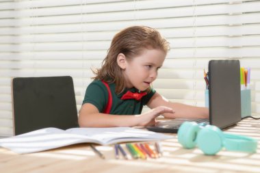 Schoolboy pupil studying at home using laptop. Home school, online education, home education. clipart
