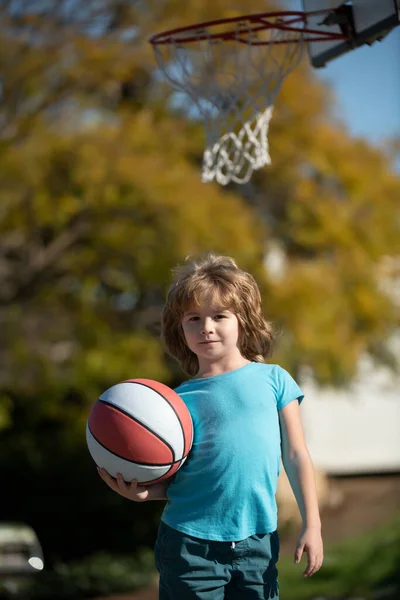 Cute little boy holding a basket ball trying make a score. Sport for kids. — Stock Photo, Image