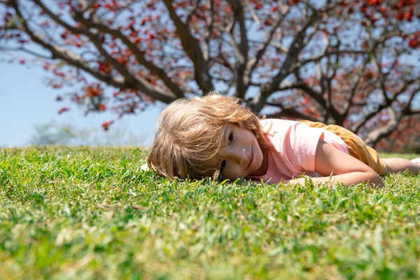 夏の自然公園で草の上に寝そべっている子供の肖像画. — ストック写真