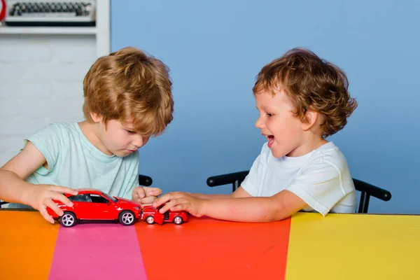 Children playing with toy car at kindergarten. Children pupils from elementary school. Caucasian kids boys plays with colorful toy cars.