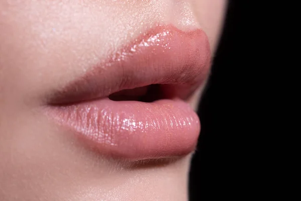 아름다운 입술을 클로즈업합니다. 얼굴의 일부로서, 젊은 여자는 두툼 한 입술을 벌거벗은 립스틱으로 감싼다. 커다란 입술에 붙어 있는 천연 입술. — 스톡 사진