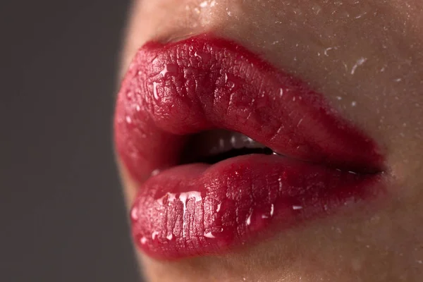 Χείλη. Ένα μέρος του γυναικείου προσώπου από κοντά. Σέξι παχουλό χείλος με μακιγιάζ. Χείλη, κόκκινο κραγιόν, στόμα απομονωμένο. Σέξι κοριτσίστικο στόμα από κοντά. Αισθησιακή γλώσσα στο στόμα μιας νεαρής γυναίκας. Καλλυντικά και κοσμετολογία. — Φωτογραφία Αρχείου