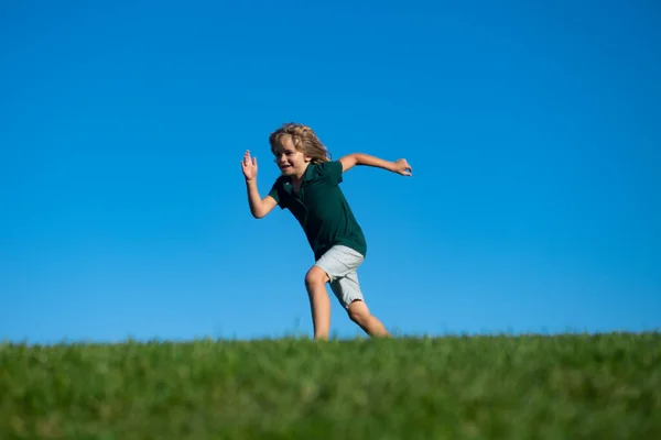 Счастливые дети играют и бегают на траве под открытым небом в летнем парке. Активные дети на открытом воздухе. Веселая деятельность. — стоковое фото