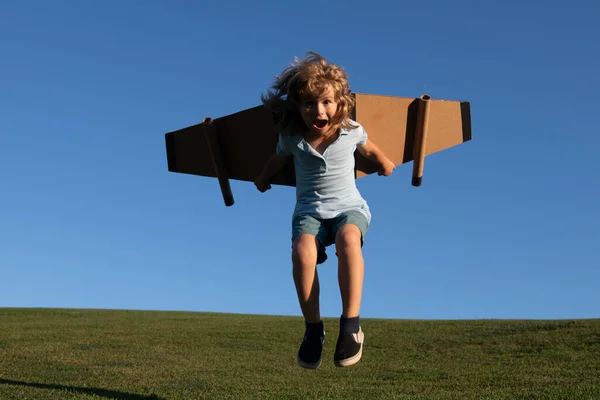 面白い子供ジャンプやおもちゃのジェットパックで実行しています。子供のパイロット宇宙飛行士や宇宙飛行士の夢。ボールボードの翼を持つ飛行士の少年. — ストック写真