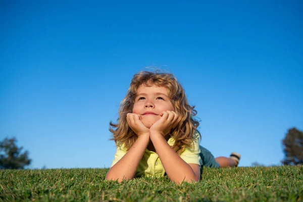 Gelukkig kind dat op groen gras speelt. Grappig kind buiten in de voorjaarstuin. Kinderdagconcept. — Stockfoto