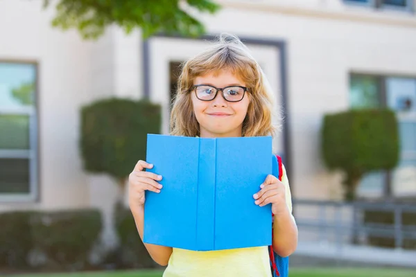 Écolier excité avec livre à l'école. — Photo