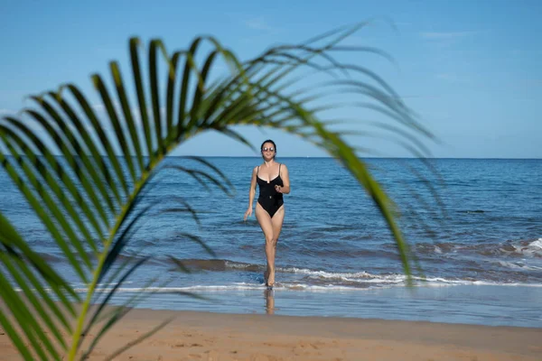 Mujer joven corriendo en una playa. Playa paradisíaca tropical con arena blanca y palmeras, Concepto de turismo de viajes. —  Fotos de Stock