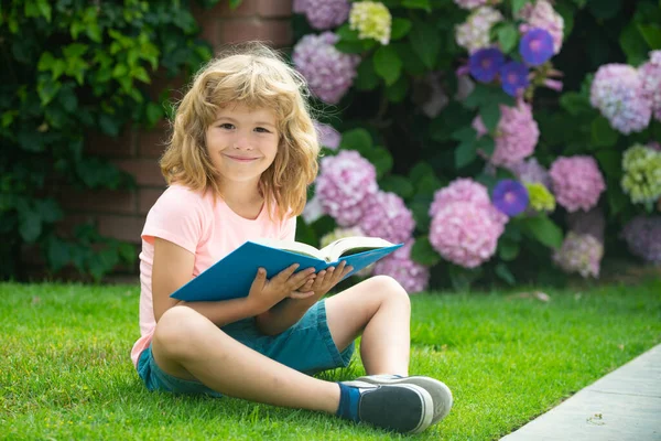 Schattig kinderboek buiten. Kind leest boek in park. — Stockfoto