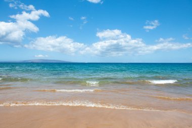 Kumlu sahilde mavi okyanus dalgası. Yaz mevsiminde gün batımında plaj. Plaj manzarası. Tropik deniz manzarası, sakinlik, dinlendirici güneş ışığı.