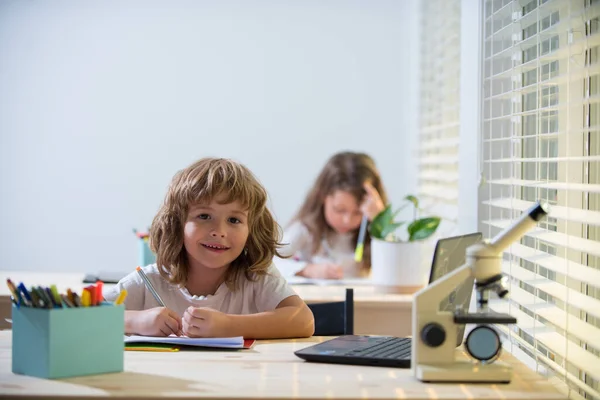 Iskolásfiú ül az asztalnál, házi feladatot ír, vagy a vizsgára készül. Gyerektanulás. Kis diákok tanulása. — Stock Fotó