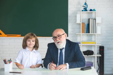 Okuldaki mutlu çocuk. Öğretmenin öğrenmesine yardım et. Eğitim, öğretmenlik, ilkokul