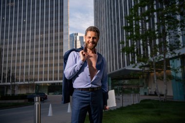 Takım elbiseli beyaz iş adamı ofisten çıkıyor. Son çalışma günü konsepti. Seksi moda işadamı.