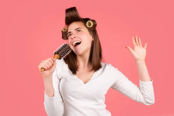 Una mujer divertida cantando con peine. Chica peinando el pelo. Hermosa mujer joven sosteniendo peine alisado cabello. — Foto de Stock