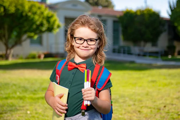 Estudante de escola sorridente com livro de mochilas. Retrato de estudante feliz aluno ao ar livre. — Fotografia de Stock