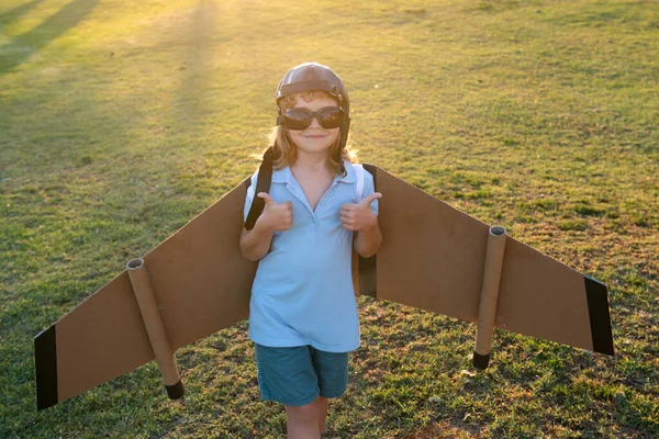 Barnpojken leker med flygplansvingar. Dröm om att bli pilot. Superhjälten flyger. Pojken drömmer om att flyga. bekymmersfritt barn leker utomhus. — Stockfoto