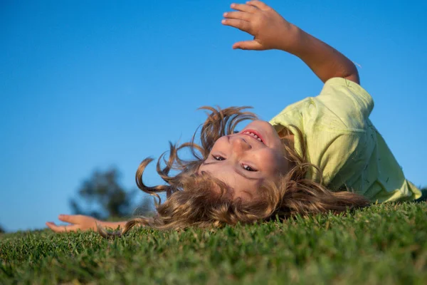 Glada barn leker på grönt gräs. Rolig unge utomhus i vårträdgården. Barnens dag. Glad bekymmerslös barndom koncept. — Stockfoto