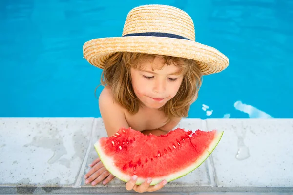 Niño con sandía sonriendo nadando en la piscina en verano en el complejo. Niños con trozo de sandía al aire libre. Vacaciones de verano y concepto de alimentación saludable. — Foto de Stock