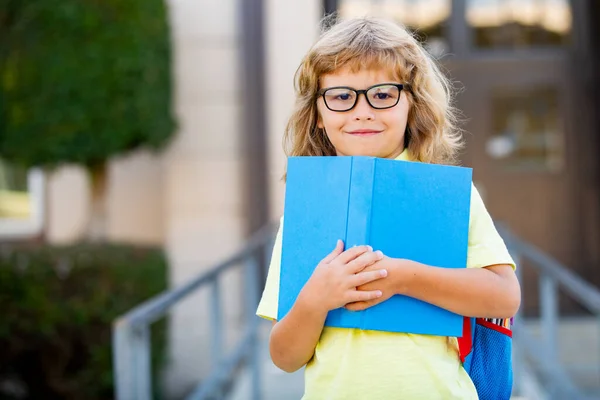 Écolier excité avec livre à l'école. — Photo