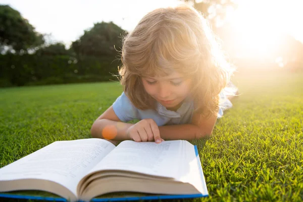 Söt pojke med böcker utomhus. Sommarläger. Begreppet lärande och utbildning för barn. — Stockfoto