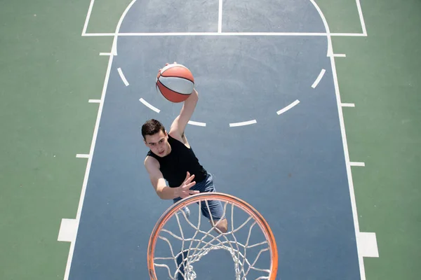 Angolo vista di uomo che gioca a basket, sopra il cerchio di uomo che spara basket. — Foto Stock